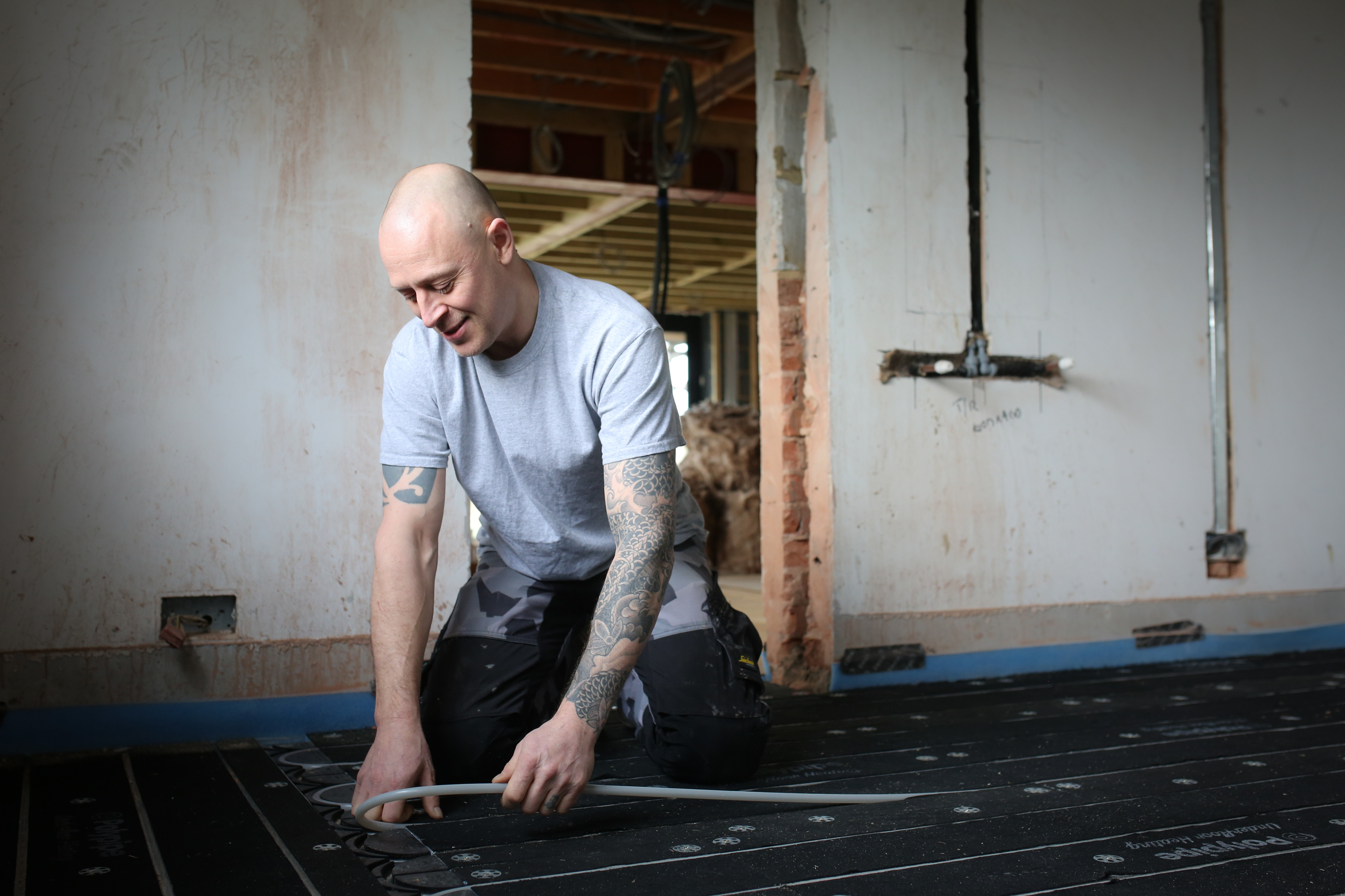 Ryan Faint (of FMS Contractors) lays Polypipe's underfloor heating pipe into their Overlay Plus panels.