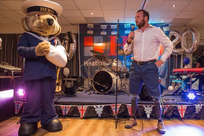 Luke Sinnott, Ambassador for Help for Heroes speaks to the room along with the Help for Heroes Bear.