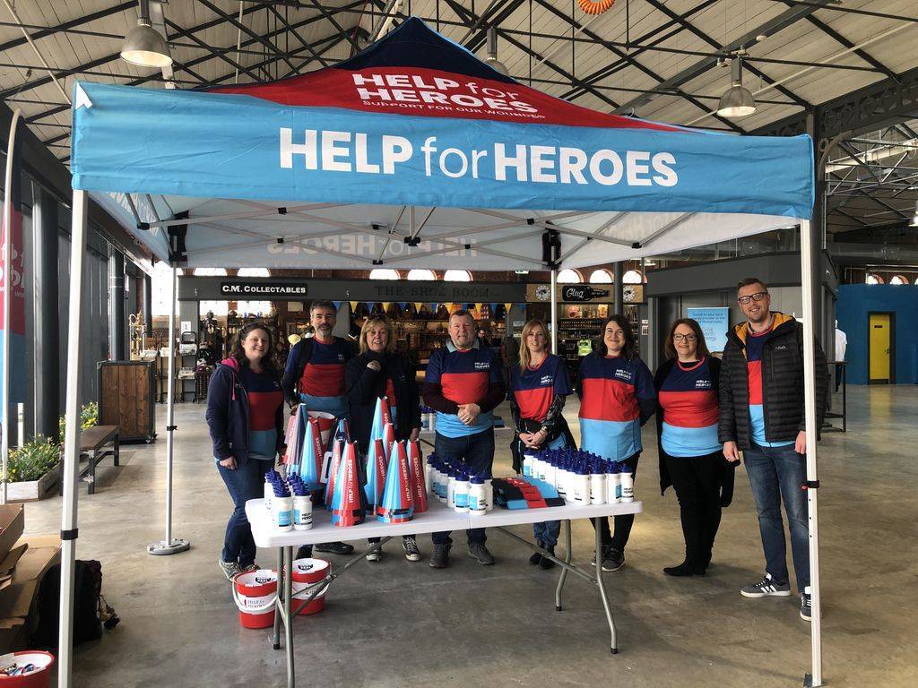 Polypipe staff stand under a Help for Heroes branded tent, with volunteers who are fundraising for H4H at Le Tour De Yorkshire