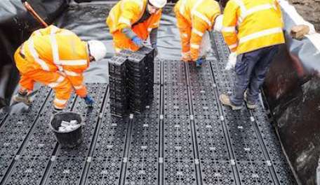 Melina Road Case Study. Picture of four workmen installing the Polypipe Permavoid tanks. 